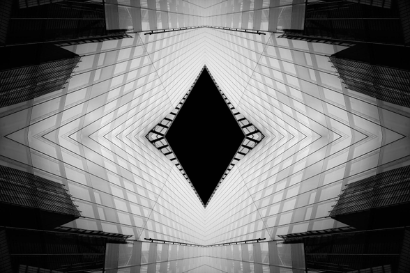 An abstract black and white architecture photo, reflected to make a perfectly symmetrical pattern with a black diamond in the centre.