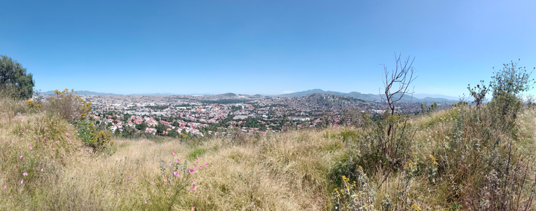 a panorama photo from the top of a hill with the view of a town in the distance