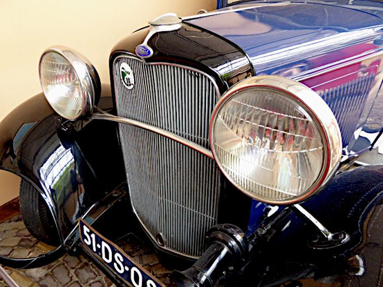 Foto van de voorkant (grille en grote koplampen) van een antieke Ford auto