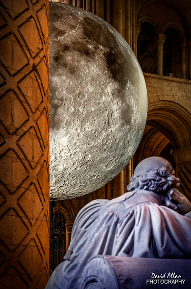 A partial lunar eclipse – Luke Jerram's 'Museum of the Moon' appearing from behind Durham Cathedral's ancient Norman architecture.