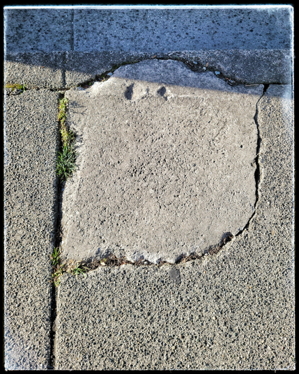 This image shows acrack in the sidewalk that closely resembles a (not so) scary ghost.