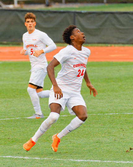 In the center a black man is looking up at an incoming ball, he's got number 24,  no 5 behind him is looking in his direction