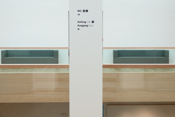 two couches and a pilar in a corridor