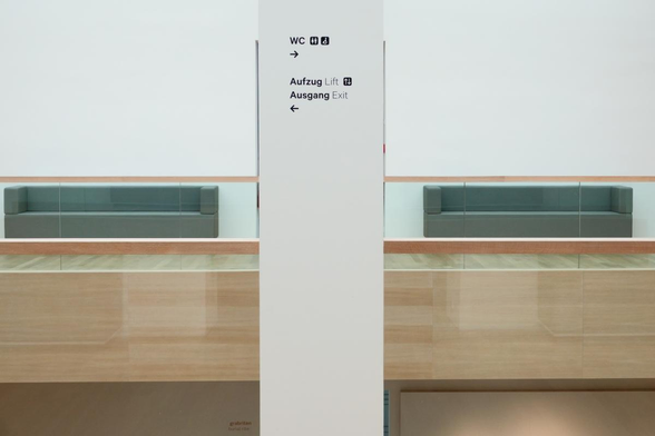 two couches and a pilar in a corridor