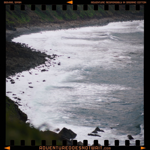 A dramatic coastline in Bizkaia, Spain, where the Atlantic Ocean crashes against rugged cliffs and rocky shores. This raw seascape inspires organic cotton clothing with adventure-themed designs, blending sustainability and coastal energy.