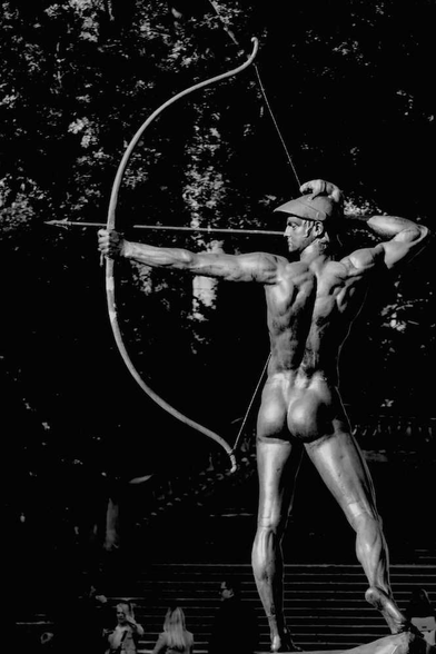 Statue eines nackten Bogenschützen von Ernst Moritz Geyger. Rückansicht. Park Sanssouci, Potsdam.