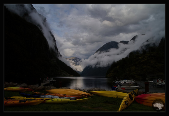 Gudvangen after the warm rain. Low clouds over the fjord. With kayaks on the first plan.