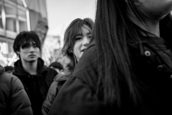 Cara de dona mig amagada darrere d'una altra dona