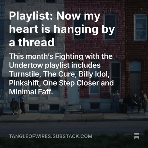 Still from Turnstile’s 'Look Out for Me' video showing band members looking small against tall coloured buildings