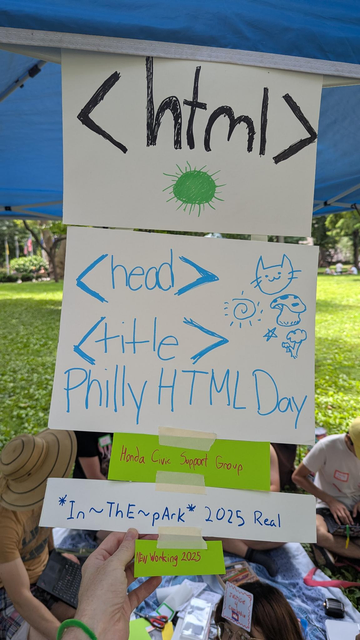 a collection of papers that have been hand-written by several people

html header tag in black, green html energy sun drawing
blue head and title opening tag 
title starts with "philly html day"
in red, the lines continues "honda civic support group"
in blue it continues "2025 in the park real"
in red continues "NEW working 2025"
