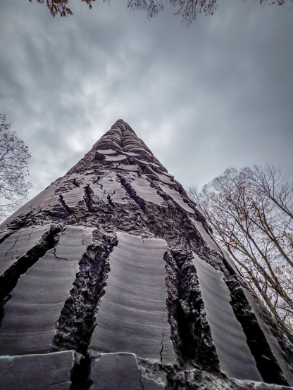 Looking up along the side of a large monolith type scupture with groves