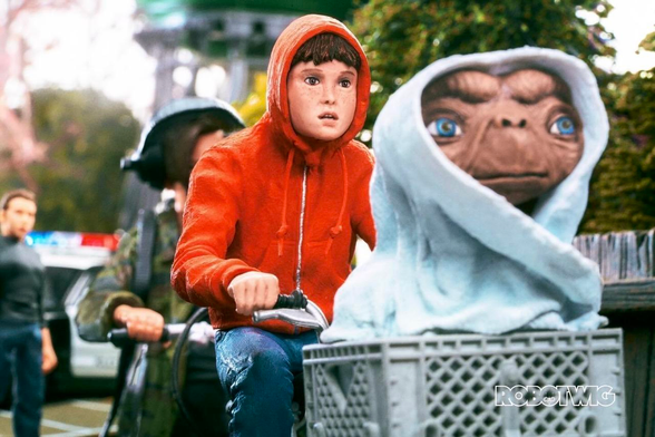 Elliot rides on his BMX down a street away from the cops with ET in the basket