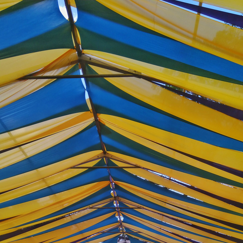 Colorful canopy with alternating yellow and blue fabric panels stretched over a metal frame
