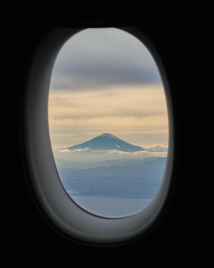 A view of Mount Fuji taken from around 8,200 feet in the air as the flight was descending into Tokyo's Haneda Airport.

Mount Fuji is basked in the afternoon light, framed by a plane's window. The summit of Mount Fuji shows a little snow, taken around a week after 2025's first snow on Mount Fuji.