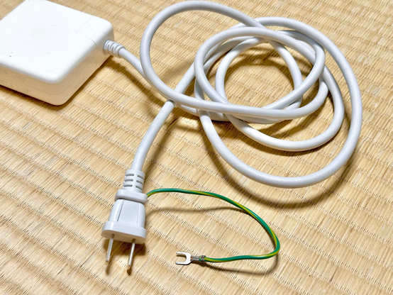 A mains power cord with a two-pronged US-style plug on the end, except there's also a yellow green ground cable sticking out the side of it with a screw-in "pitchfork" on the end
