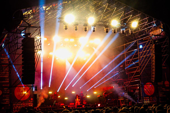 A band performing on an outdoor stage at night.