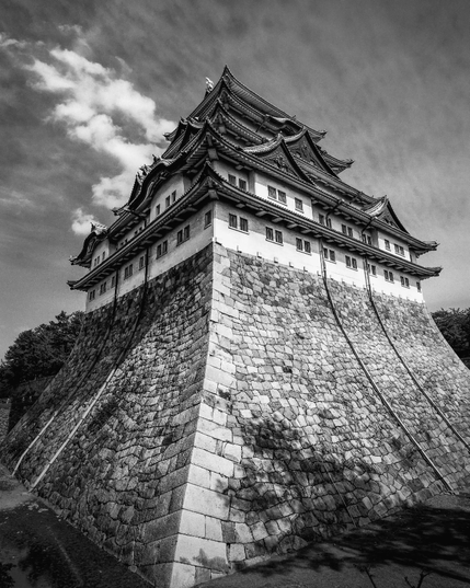 Un típico castillo japonés visto desde la base con un gran angular. Primero hay como unos 10 metros de rocas apiladas formando una base (sin ventanas y aberturas) que se encuentra dentro de un foso (ahora sin agua). Luego comienzan las plantas del castillo: de base cuadrada, muros blancos, pequeñas ventanas y techos curvos, una encima de otra y cada vez más pequeñas.