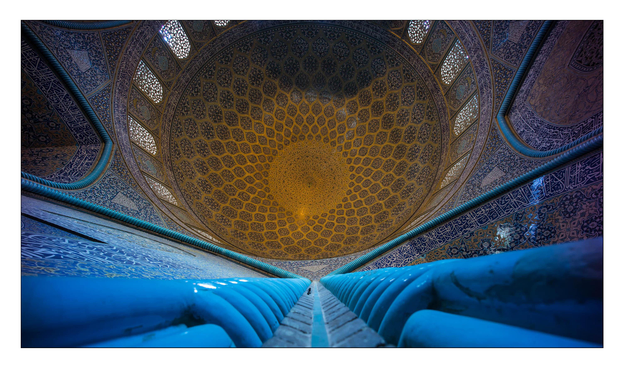 Innenaufnahme der Lotfollah Moschee in Isfahan. Deckenmosaik. Am unteren Bildrand blaue Säulen. Vertikal nach oben fotografiert.