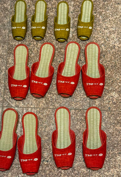 Colorful indoor slippers in different sizes for visitors waiting on the floor in Japan
