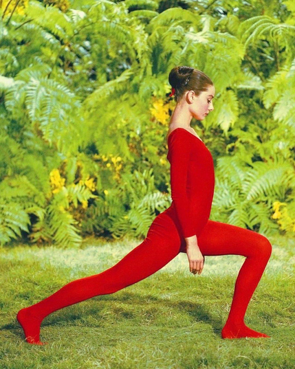 Audrey Hepburn en justaucorps rouge effectue une fente avant dans la jungle