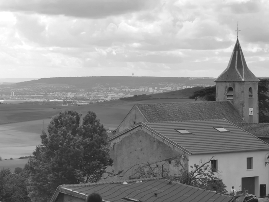 Vue sur depuis le village d'Amance vers la vallée. L'église est au premier plan, le paysage vers Nancy s'ouvre derrière