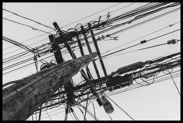 A view looking up a wooden telephone pole with a rat's nest of several dozen wires, transformers, lights, and doohickeys overhead. Taken on slow and quiet Sanchez Street, in the heart of Noe Valley.

Monochrome. Ugly, yet beautiful.