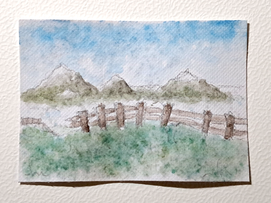 Une carte représentant un paysage montagnard, dont les vallées sont remplies de brume formant comme une mer de nuages avec les sommets apparaissant comme des îles ; une barrière délabrée en bois sépare la caméra du vide.