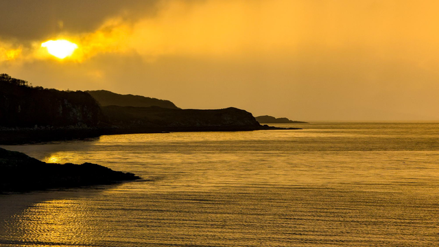 A tinge of gold at sunset with silhouetted land jutting out into the sea loch Loch Eishort, Isle of Skye,  Scotland 