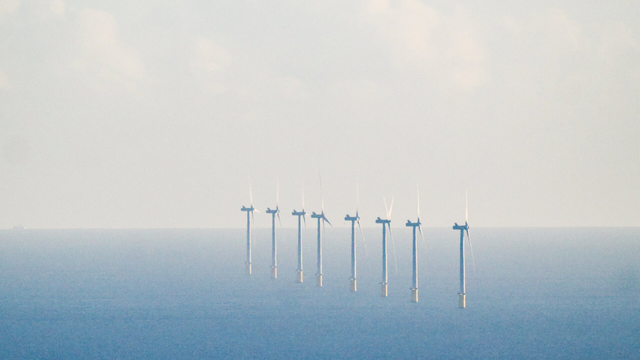 Wind turbines in a calm sea .