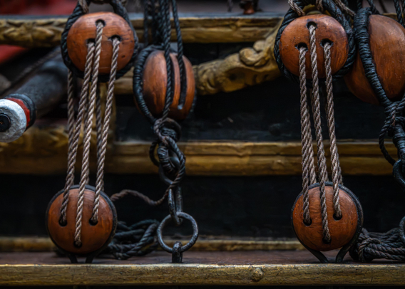 A photo showing some details from the model of the ship William Rex at the Rijksmuseum, including some rigging with blocks and rope.

