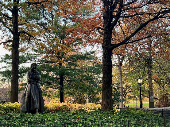 Photo by Fenichel: Eleanor Roosevelt (statue) at the Southern end of Riverside Park in Manhattan's Upper West Side. She's too the left, foreground, while the rest of the frame is trees in various stages of fall foliage. 