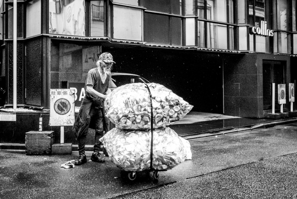 Sense sostre empenyent un petit carro amb dues bosses de llaunes , de bon matí als carrers de Kabukichó.