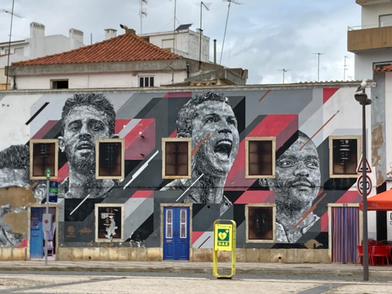 Street Art in Portimao (Algarve). Auch wenn es schon etwas ramponiert ist, bekommt man hier noch 4 Helden der fussballbegeisterten Nation zu sehen.
Auf einer tristen Fassade sind zwischen den Fenstern und Türen überlebensgross die Portraits von CR-7 und seinen Mitspielern (?) in Siegerpose verewigt.