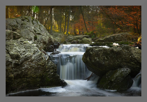 Photo d'une petite cascade dans une rivière sauvage. Elle est entourée de gros rochers, à l'arrière plan on apperçoit la forêt baignée par la lueur du soleil levant qui fait ressortir le rouges des feuilles d'automne
-
Photo of a small waterfall in a wild river. It is surrounded by large rocks, and in the background you can see the forest bathed in the glow of the rising sun, which brings out the reds of the autumn leaves.