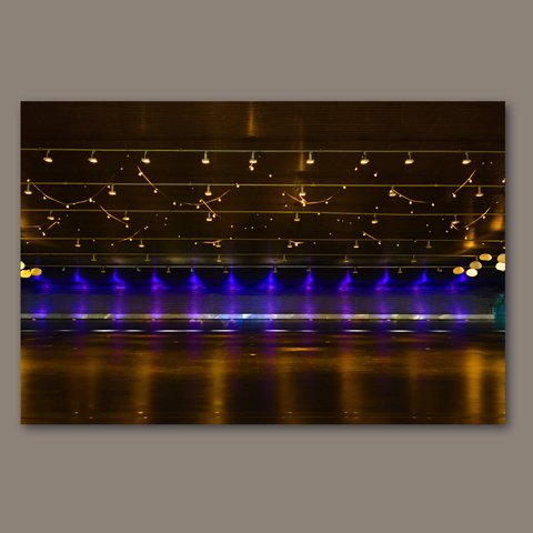 Blues and yellow lights reflecting un the floor of a closed space.