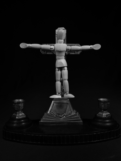 Mannequin trop grand sur un crucifix.