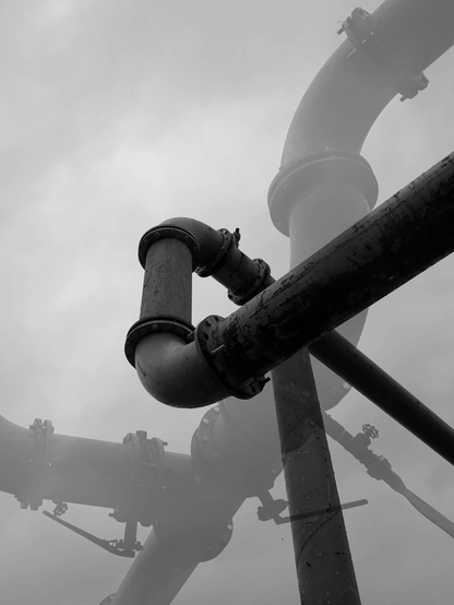A montage of black and white photographs of pipes in front of a gray sky, that seeks a blurry abstraction, a sensation ashes and wandering.
