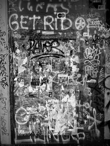 A montage of black and white photographs of a door with graffiti, that seeks a blurry abstraction, a sensation ashes and wandering.
