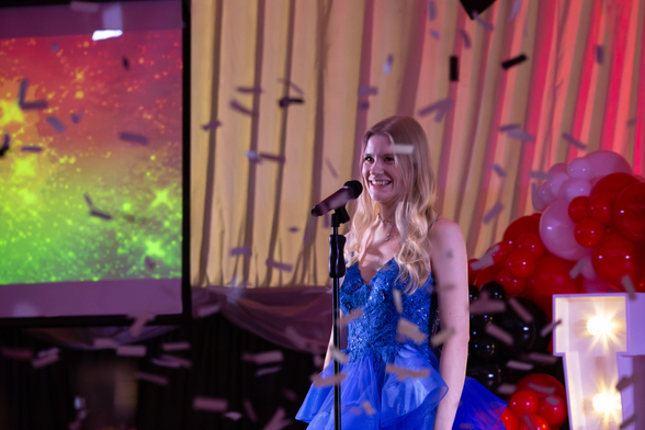 Singer on stage in blue dress with confetti flying down from the air