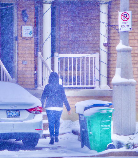 Person outside at home in a snowfall.