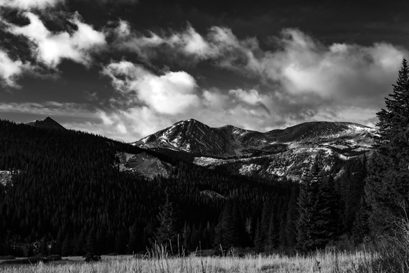 A mountain range in the distance under large clouds 
