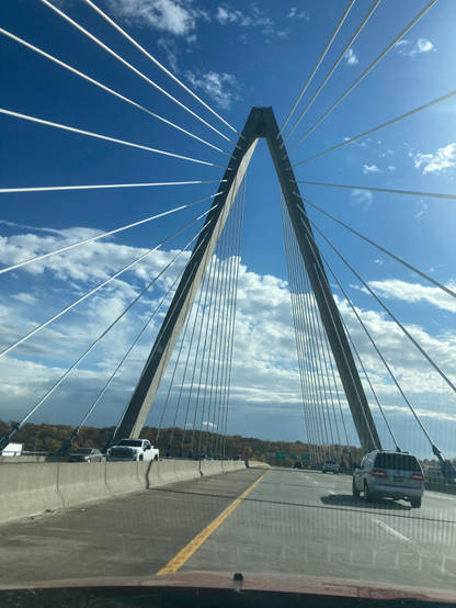 Looking up at the Christopher S Bond bridge over the Missouri River in Kansas City. It’s a modern suspension bridge using a single arch and multiple suspension cables