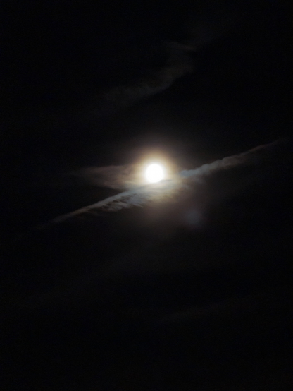 Der Mond hinter Wolken bei Nacht.