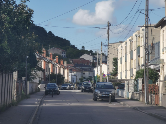 Rue résidentielle, à gauche les alignements de la cité ouvrière, à droit des immeubles plus récents.