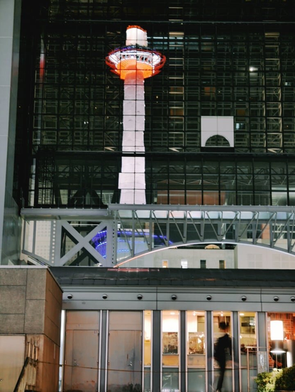 Kyoto Tower as reflected in the JR Kyoto station at night.