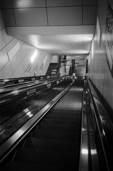 지하 지하철역을 향해 내려가는 기다란 에스컬레이터. 저 멀리 끝이 보인다.