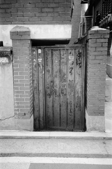 주택가 벽돌 담장에 작은 철문이 달렸다. 벽돌기둥 사이에 달린 철문은 녹이 많이 슬었다.