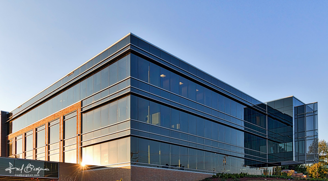 Newly constructed office building with glass walls that reflect the setting sun in Brentwood, TN