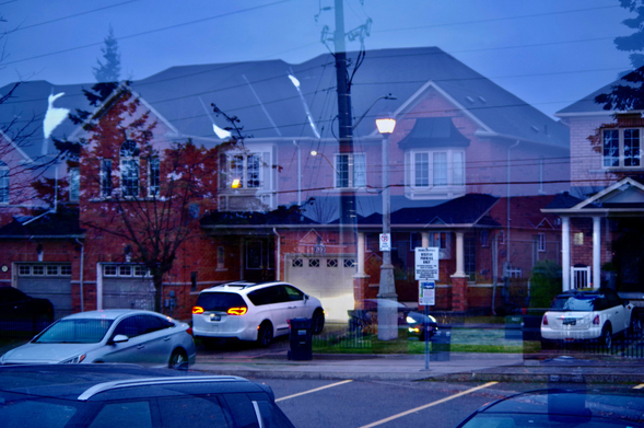 In-camera processed Composite Image of one Municipal road and one Residential street; with their lights and cars, homes and fences.