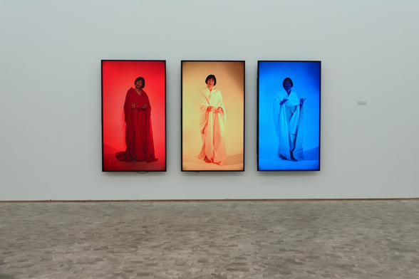 Three screens with different colors and a woman on display